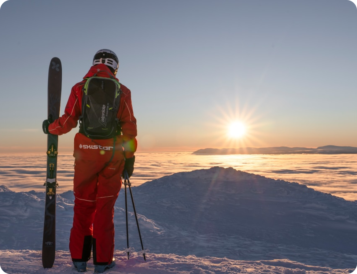 Skidåkare i röd jacka blickar ut över snötäckta berg i Åre - del av Go Gotland AB:s nya affärsområde utvecklat med hjälp av Berrycloud